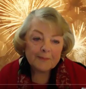 Screen shot image of an end of the year guided meditation. image of older woman in zoom giving a meditation service wearing read with a short bob hair cut.